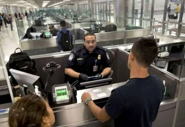 A police officer at a check-in counter Description automatically generated