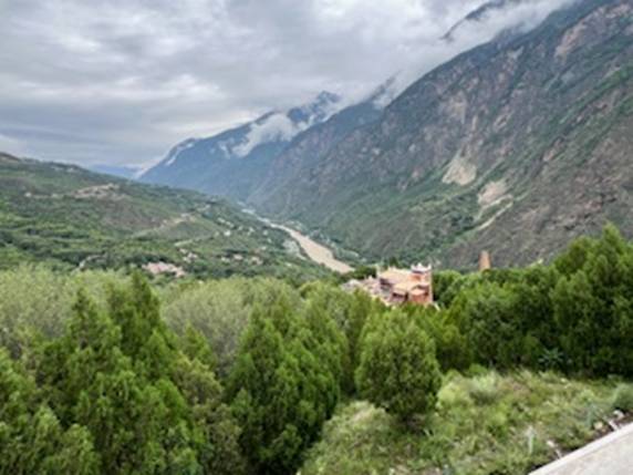 A view of a valley with trees and mountains Description automatically generated